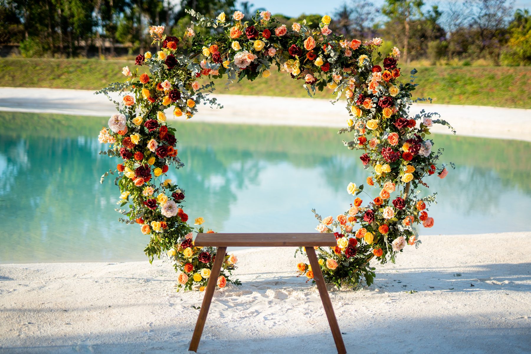 Arco floral circular diante do lago de águas claras