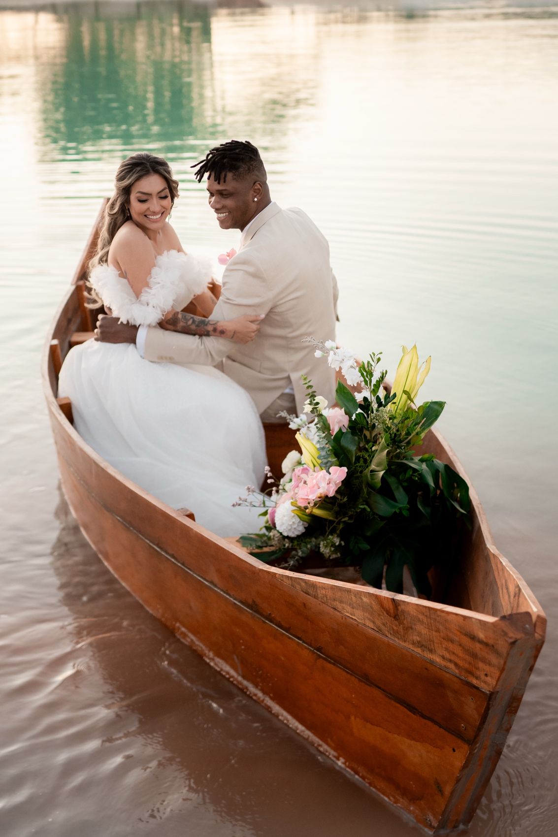 Casal de noivos em um barco de madeira no lago