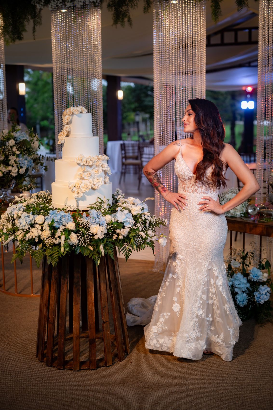 Noiva ao lado do bolo de casamento entre colunas de cristal